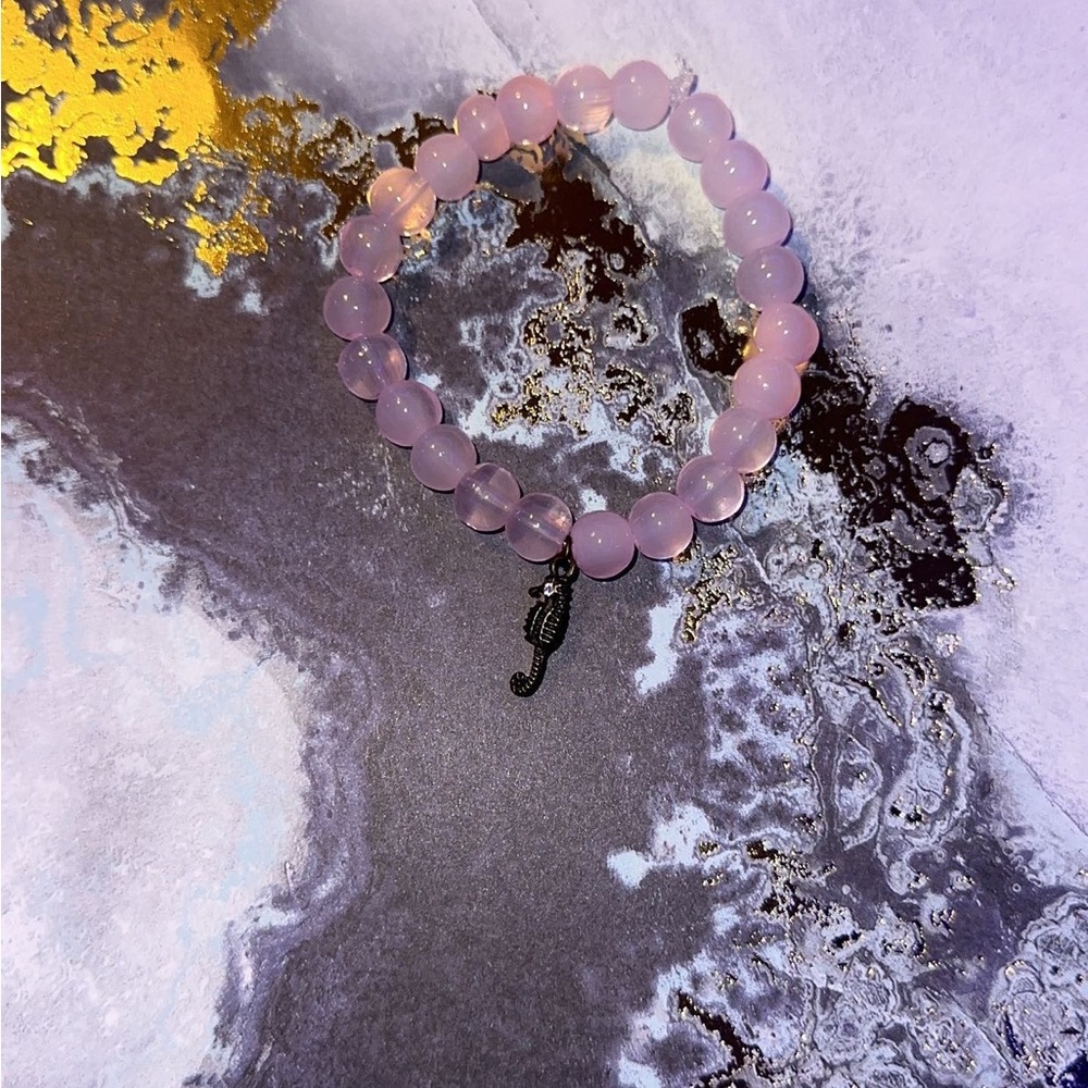Pink marble bracelet with a sea horse attached to the bottom